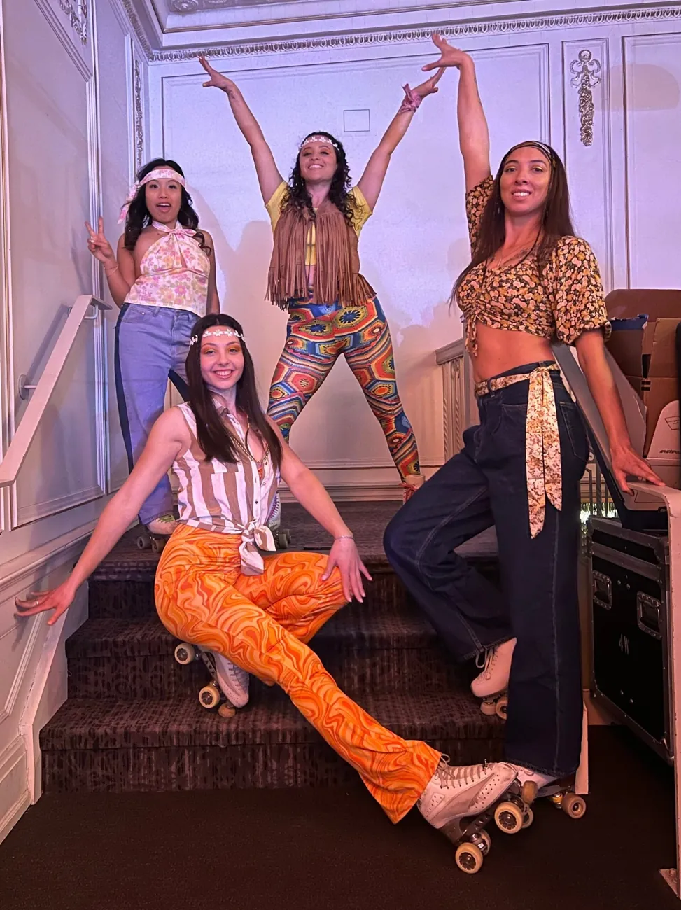 Three skaters in colourful outfits posing on a staircase